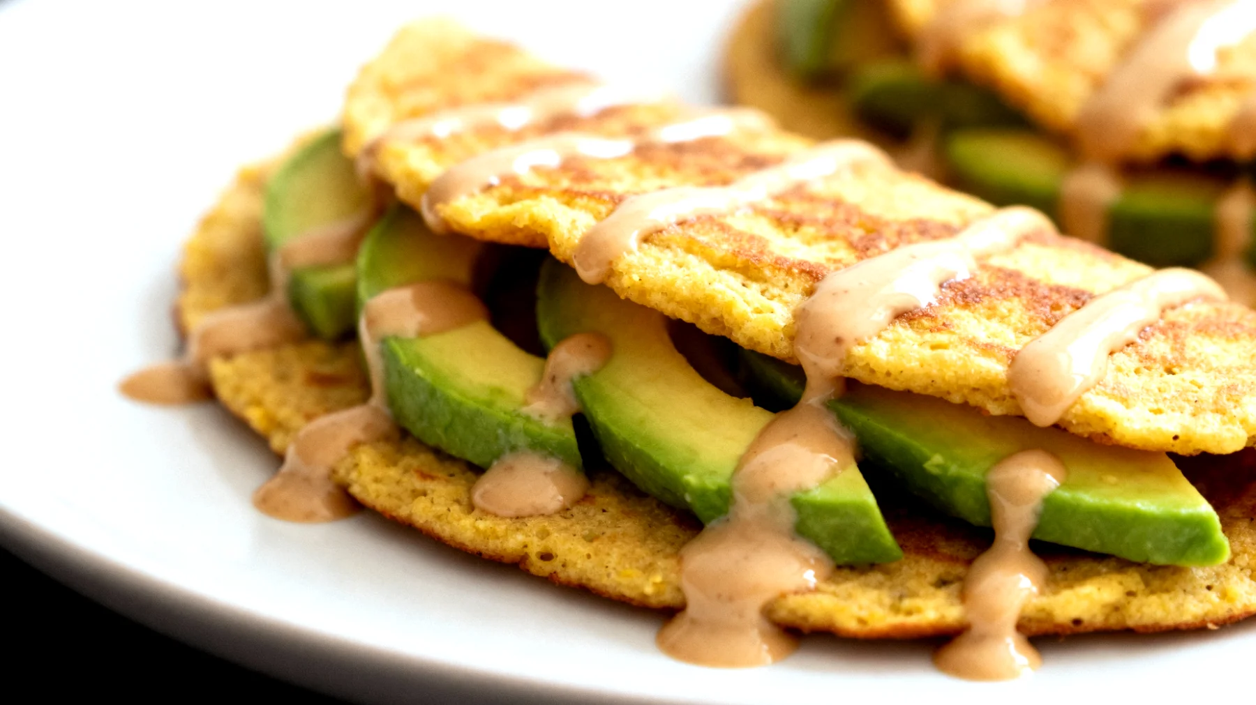 Kichererbsen-Pancakes mit Avocado und Sesampaste (Socca-Wraps)"